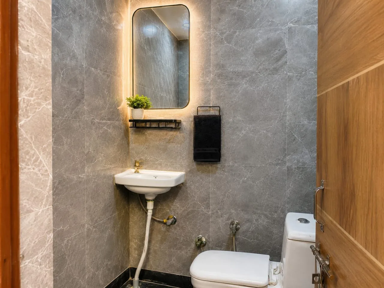 Modern bathroom at Duhomes boys PG Kamla Nagar, grey marble tiles and backlit mirror